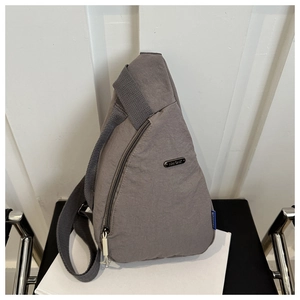 Detailed view of gray nylon crossbody bag with metal zipper and adjustable strap