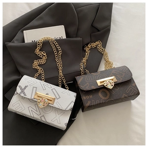 Close-up of heart-shaped gold buckles and letter-print textured leather on small square bags