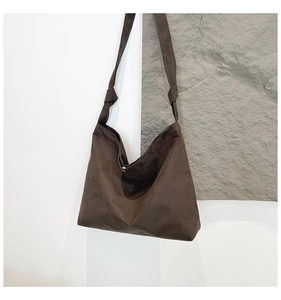 Detail of dark brown matte suede hobo bag featuring stylish knotted shoulder strap accents