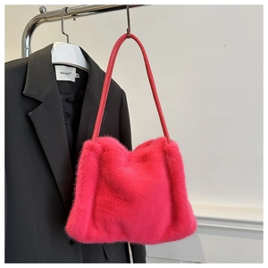 Close-up of rose red faux fur shoulder bag texture hanging on a black suit blazer