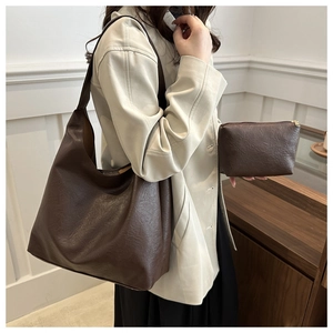 Detail of dark brown leather tote and matching pouch set with natural grain texture