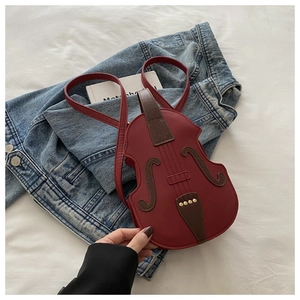 Detail of violin-shaped crossbody bag in retro burgundy with fine stitching and gold rivets