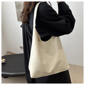 Detail view of large cream hobo bag with unique wrinkled leather texture and wide strap