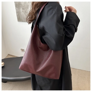 Burgundy retro tote bag with vintage embossed leather texture shown on shoulder
