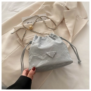 Close-up of gray marble texture bucket bag with drawstring and golden chain strap