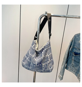 Detailed close-up of blue and white geometric canvas tote with adjustable strap