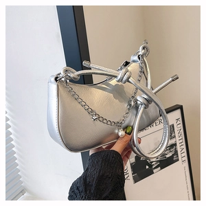 Détail du sac hobo argenté avec bandoulière nouée et pendentif étoile perle et chaîne