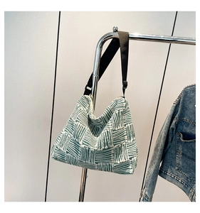 Macro detail of green and white woven canvas hobo bag with wide nylon shoulder strap