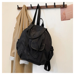 Detail of black nylon backpack with flap front pocket and elastic side pouches