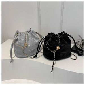 Detail view of stylish drawstring bucket bags in silver and black with chain straps