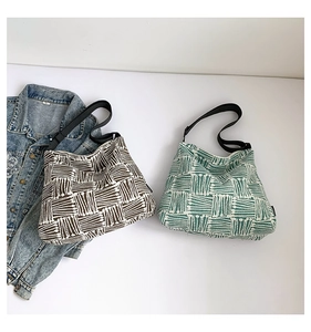 Detail of woven plaid canvas tote bags with wide black adjustable shoulder straps
