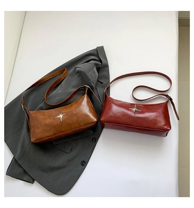 Detail of minimalist shoulder bags in brown and burgundy with silver star ornaments