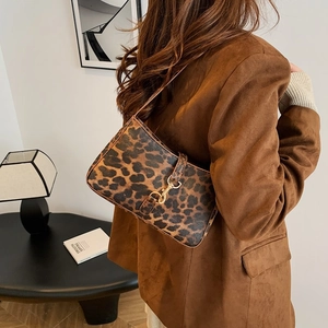 Sac à bandoulière léopard tendance avec fermoir doré porté par un mannequin femme