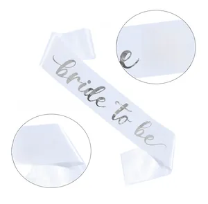 Detailed view of white satin Bride to Be sash with gold foil lettering for weddings