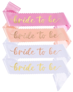 Close-up of four satin bride to be sashes in pink orange purple and white with gold font