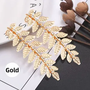Detail of gold leaf hair accessories with white crystals and intricate vein textures