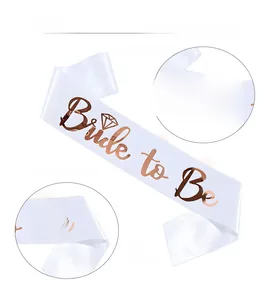 Detail showing white satin Bride to Be sash with rose gold foil lettering for bridal parties
