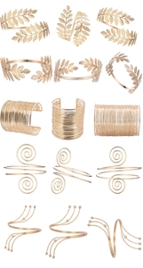 Close-up of golden multi-layer arm cuffs with leaf and spiral designs on white background