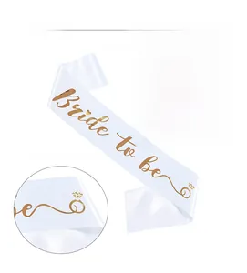 Detailed view of white satin Bride to be sash with high-definition gold foil lettering