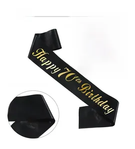 Detail of black satin sash with gold foil Happy 70th Birthday text for party decor