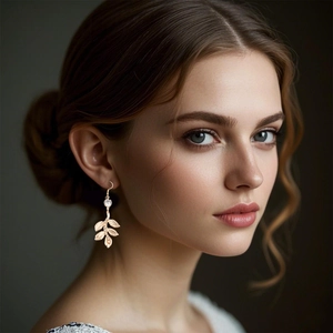 Boucles d'oreilles baroques en feuilles dorées avec cristal portées par un mannequin