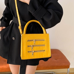 Ginger yellow crocodile pattern handbag with triple decorative zippers and top handle