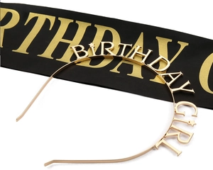 Dettaglio del cerchietto dorato Birthday Girl e fascia in raso nero per feste