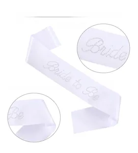 Detailed view of white satin Bride to Be sash with rhinestone lettering for bridal parties