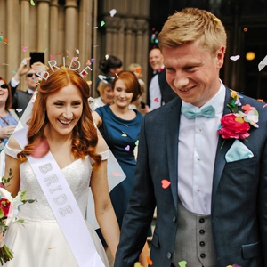 Close-up of sparkling BRIDE rhinestone headband and satin sash amid wedding confetti
