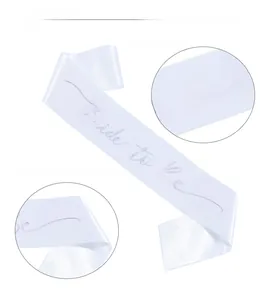 Detail of white satin sash with laser-engraved Bride To Be lettering for bridal shower