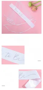Detailed view of a white lace veil and Bride to Be sash with laser lettering for party