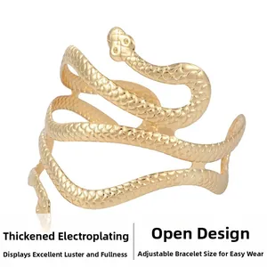 Detailaufnahme der goldenen Schlangen-Armmanschette mit Schuppenstruktur und offener Form