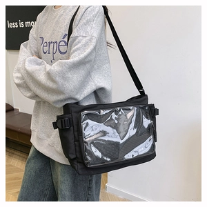 Detail view of black nylon tote bag featuring a transparent front pocket and adjustable strap