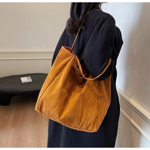 Detail of minimalist mustard suede tote bag showing front pocket and soft texture