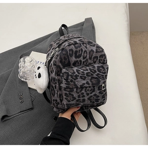 Gros plan détaillé d'un sac à dos en peluche léopard avec un charmant panda attaché