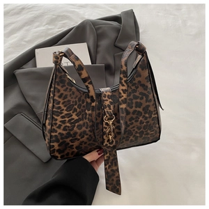 Détail du sac à main léopard avec boucles métalliques dorées et texture de cuir