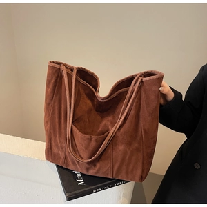 Detail of rust-red suede tote bag featuring high-quality texture and functional outer pocket