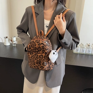 Mini sac à dos chic à motif léopard avec charm fantôme en peluche dans un café