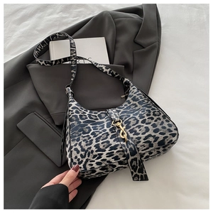 Détail du sac hobo à imprimé léopard avec crochet doré et texture de tissu raffinée
