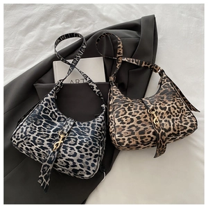 Gros plan de sacs hobo léopard vintage avec boucles métalliques sur tissu gris