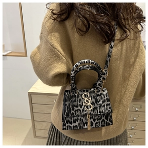 Leopard print crossbody bag detail with gold tassel and SS metallic logo accent