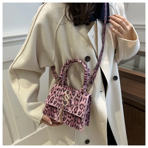 Detail of pink leopard print mini bag featuring gold hardware and elegant fringe charm