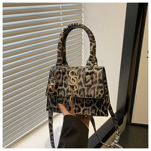 Detail of leopard print crossbody bag with gold S-logo and metal tassel hardware
