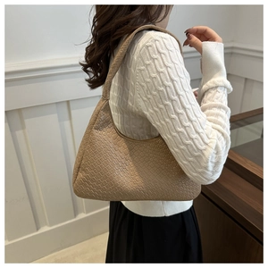 Détail du sac hobo beige avec texture en cuir tressé et structure hobo élégante