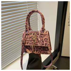 Detailed macro view of pink leopard print mini handbag with gold tassel and metal hardware