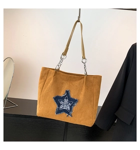 Close-up of the vintage star patch and durable faux suede texture on a tote bag