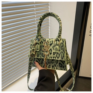 Detail of green leopard print crossbody bag with gold S-logo and long tassel charm