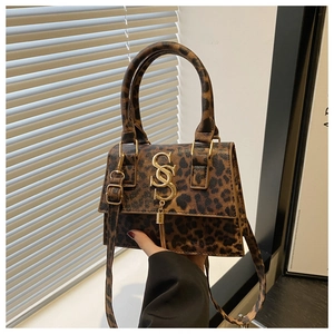 Close-up of leopard print handbag featuring a gold logo and stylish tassel detail