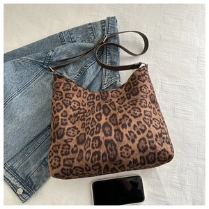 Chic leopard print hobo bag on textured surface with denim jacket for daily style