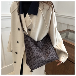 Detail of leopard print tote bag with leather strap and soft fabric texture closeup